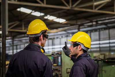 Rear view of engineer working in factory