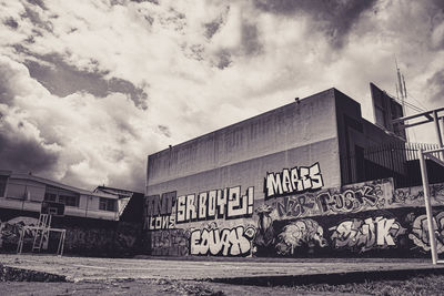 Low angle view of graffiti on wall against sky