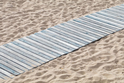 High angle view of wooden plank on sand at beach