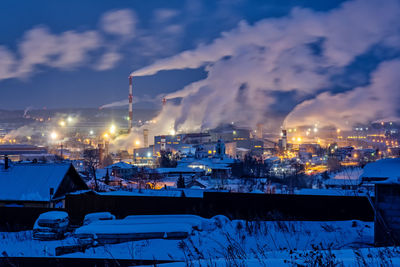 Illuminated buildings in city against sky at night