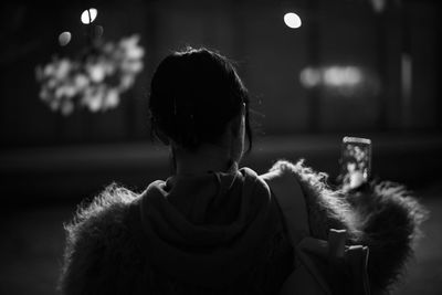 Rear view of girl sitting at home