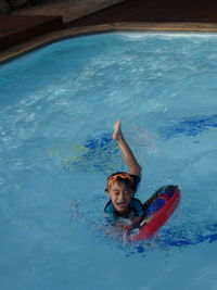 Boy swimming with inflatable ring in pool