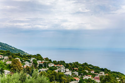 Scenic view of sea by buildings against sky