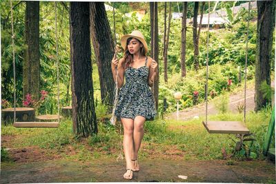 Portrait of young woman against trees