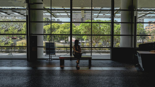 Rear view of woman walking through window