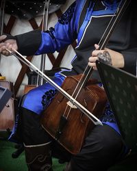 Midsection of man playing mongolian violin