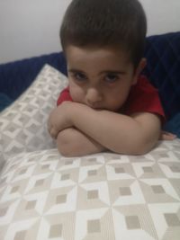 Portrait of boy relaxing on bed at home