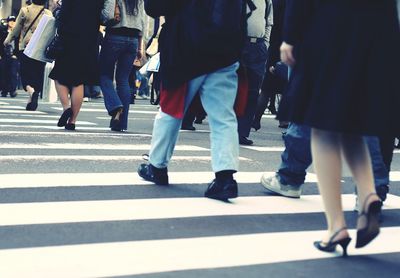 Low section of people standing on tiled floor