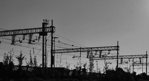 Low angle view of electricity pylon against clear sky