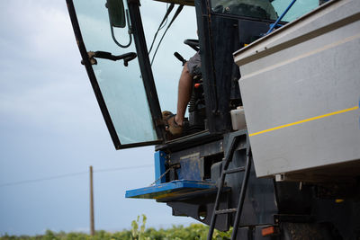 Low angle view of man operating crane