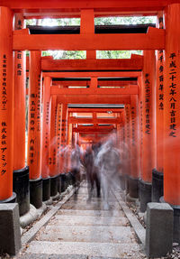 View of red train on railroad track leading towards temple