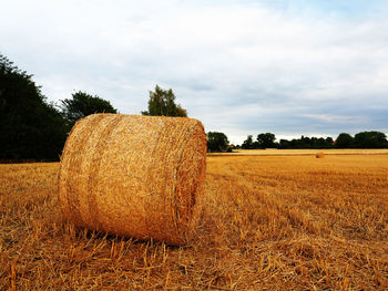 Hay bales on field against sky