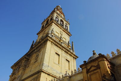 Low angle view of clock tower against blue sky