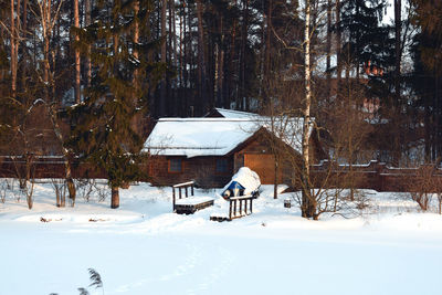 Snow covered field by building