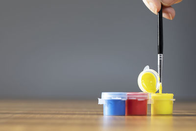 Close-up of hand holding bottle on table