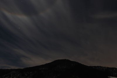 Low angle view of silhouette mountain against sky at night