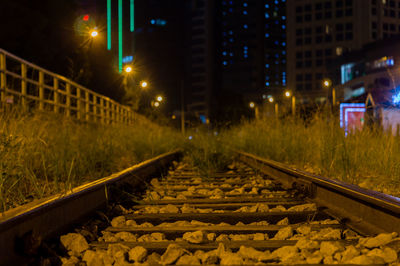 Railroad tracks in city at night