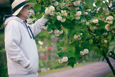 Rear view of young woman standing in greenhouse