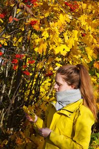Woman with yellow flowers and plants during autumn