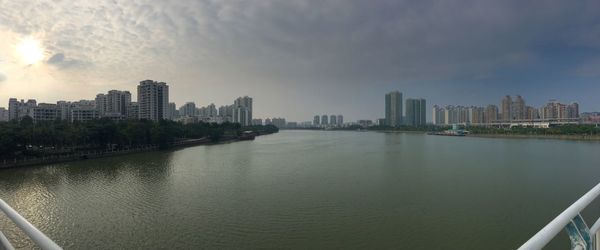 City skyline by river against sky