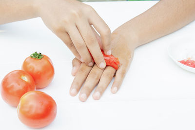 Cropped image of woman hand holding red fruit