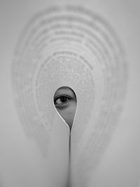 Close-up of person wearing paper against white background