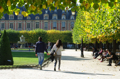 Rear view of people walking in park