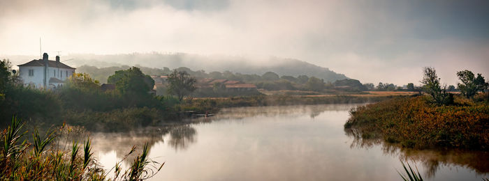 Panoramic view of lake and buildings against sky