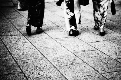 Low section of women walking on footpath