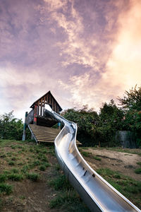 Slide at park against cloudy sky