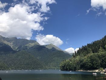 Scenic view of lake by mountains against sky