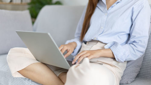 Midsection of woman using laptop