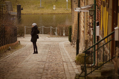 Full length of woman standing on footpath in city