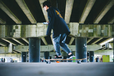 Full length of man skateboarding on street in city