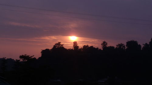 Silhouette trees against romantic sky at sunset