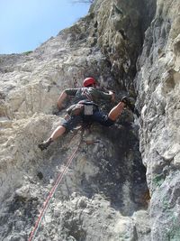 High angle view of man climbing up against sky