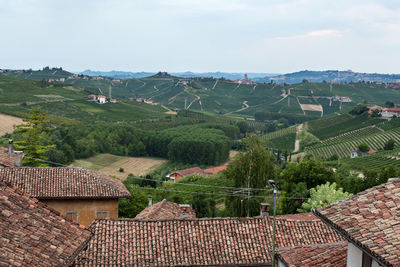 Houses and green landscape against sky