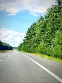 Empty road with trees in background