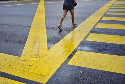 Low section of man walking on road