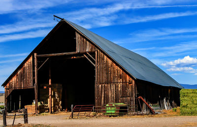 Barn on landscape against blue sky