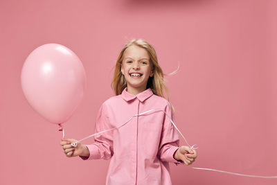 Portrait of young woman holding balloons