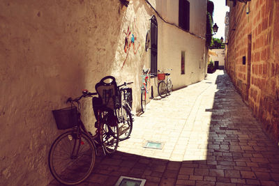 Bicycle parked on street amidst buildings