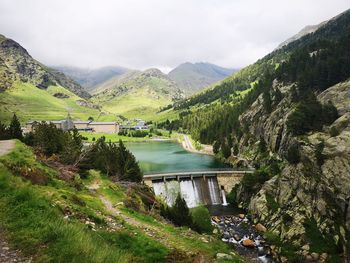 Scenic view of river by mountains against sky