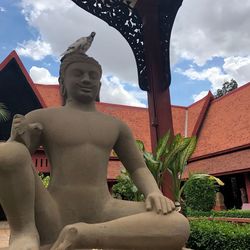 Statue against sky and building