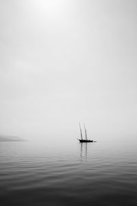 Sailboat in sea against sky