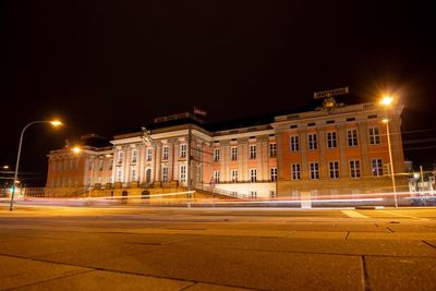 Light trails on street against buildings at night