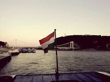 Suspension bridge over river against sky