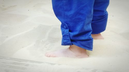 Low section of baby standing on beach