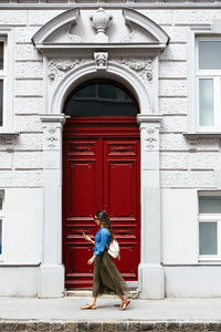 Woman with closed door of building