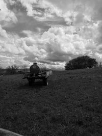 Man sitting on field against sky